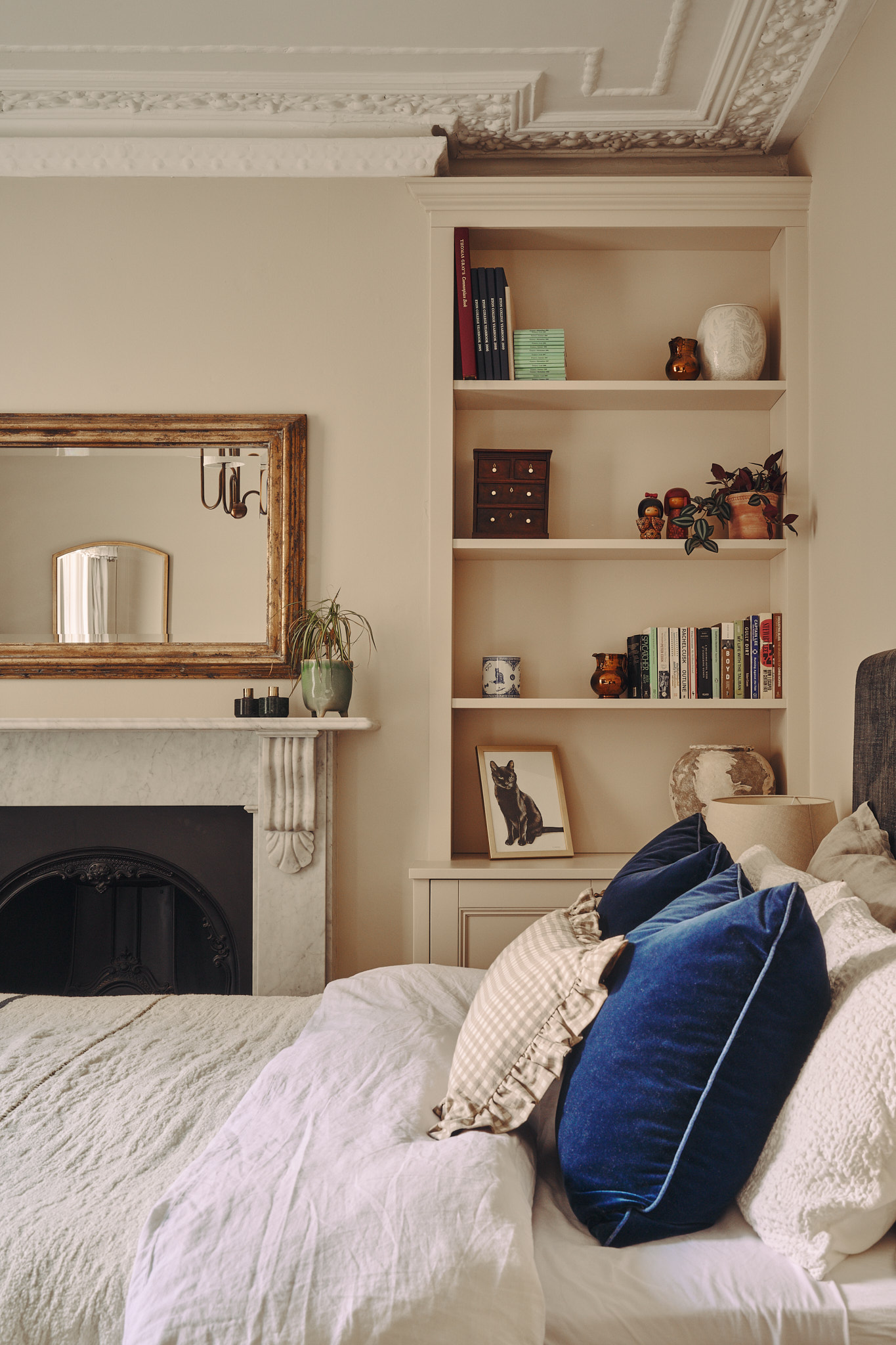A guest bedroom with fireplace and alcove shelving